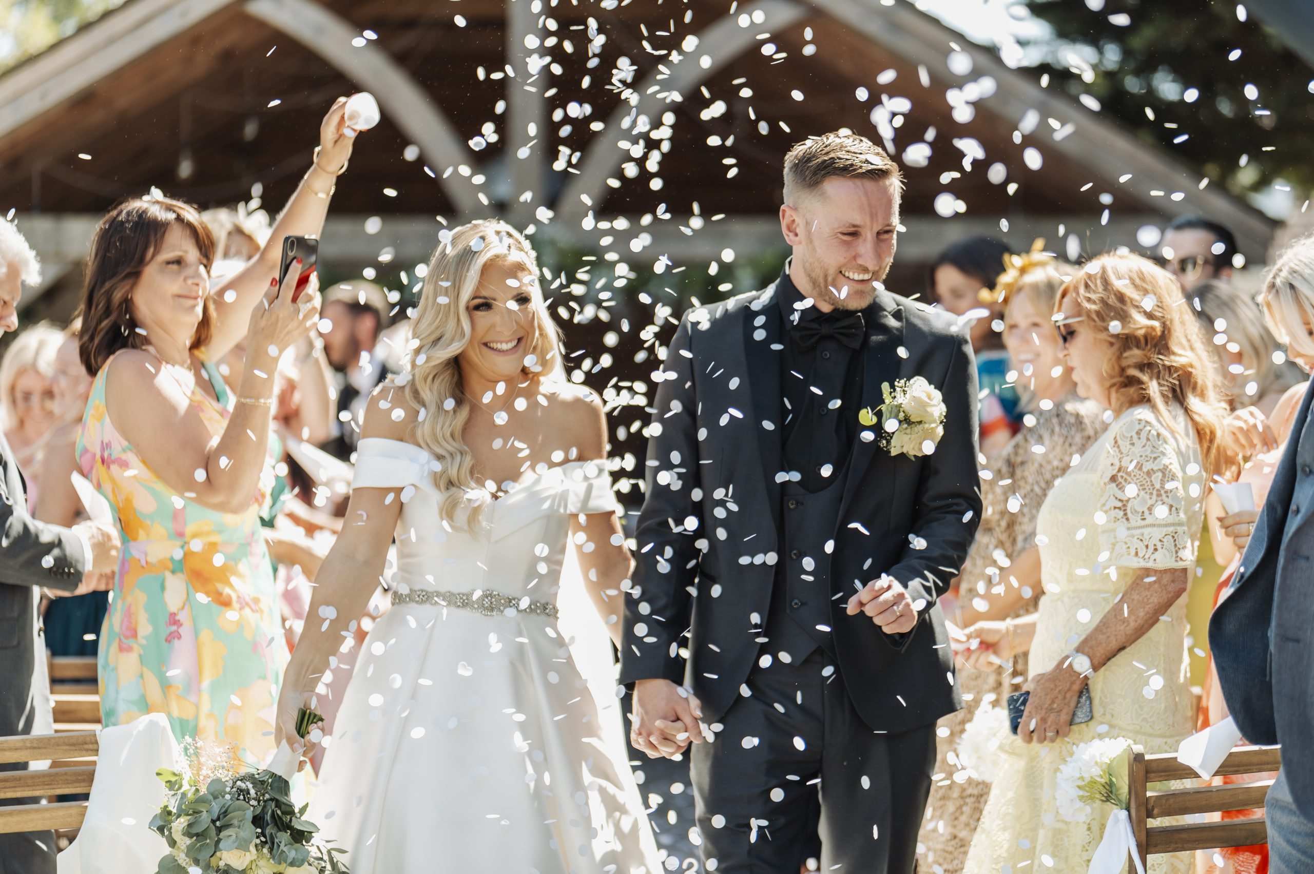 Confetti being thrown over the bride & groom