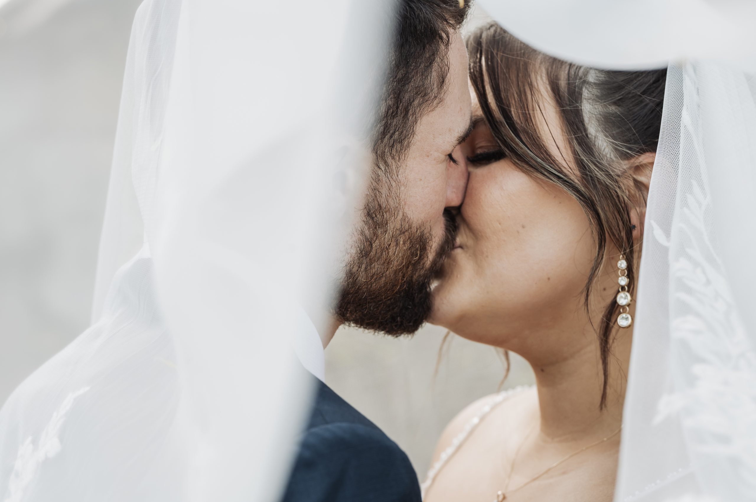 Bride & groom kissing under the veil