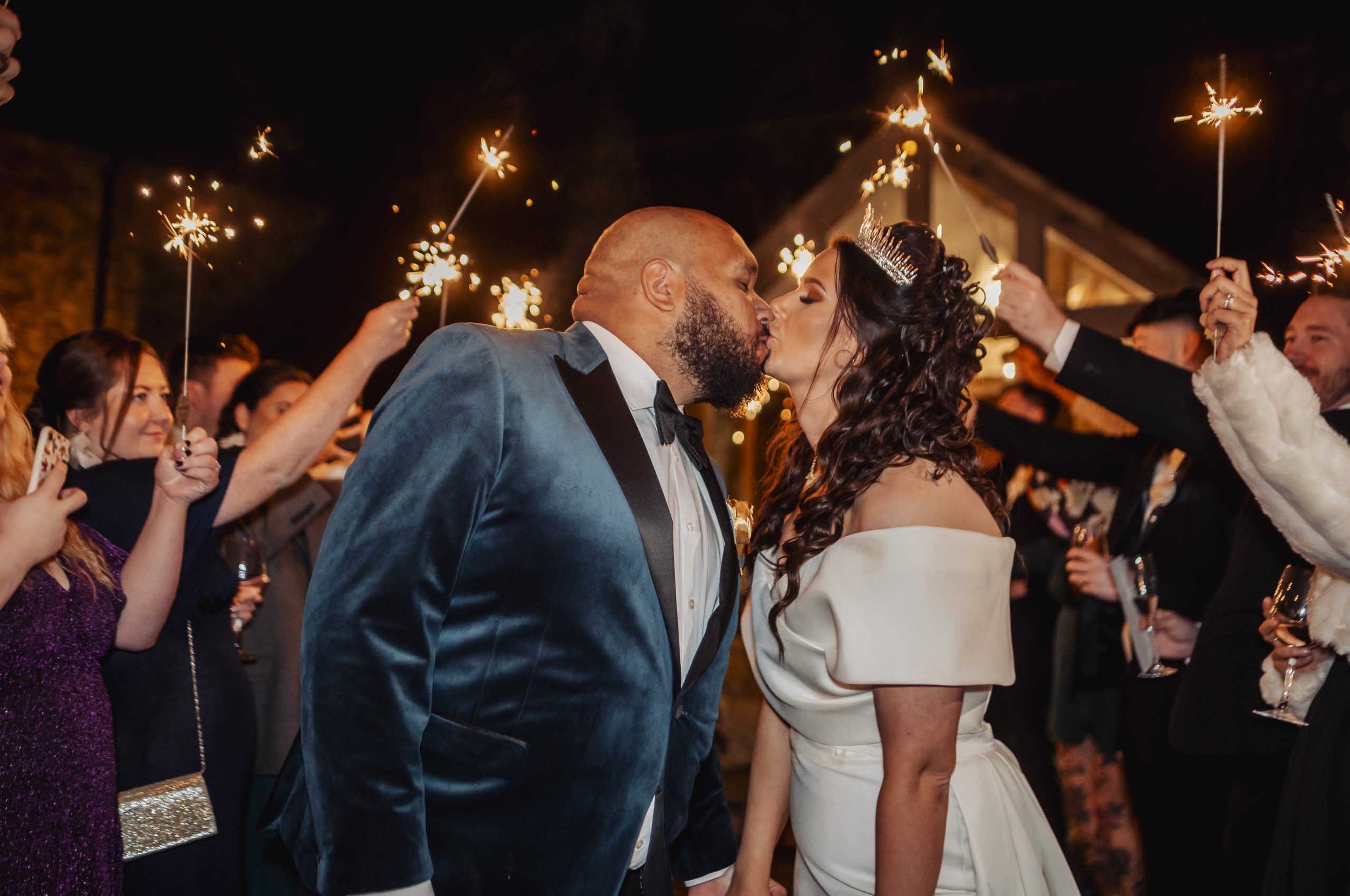 Bride & groom kissing under sparklers
