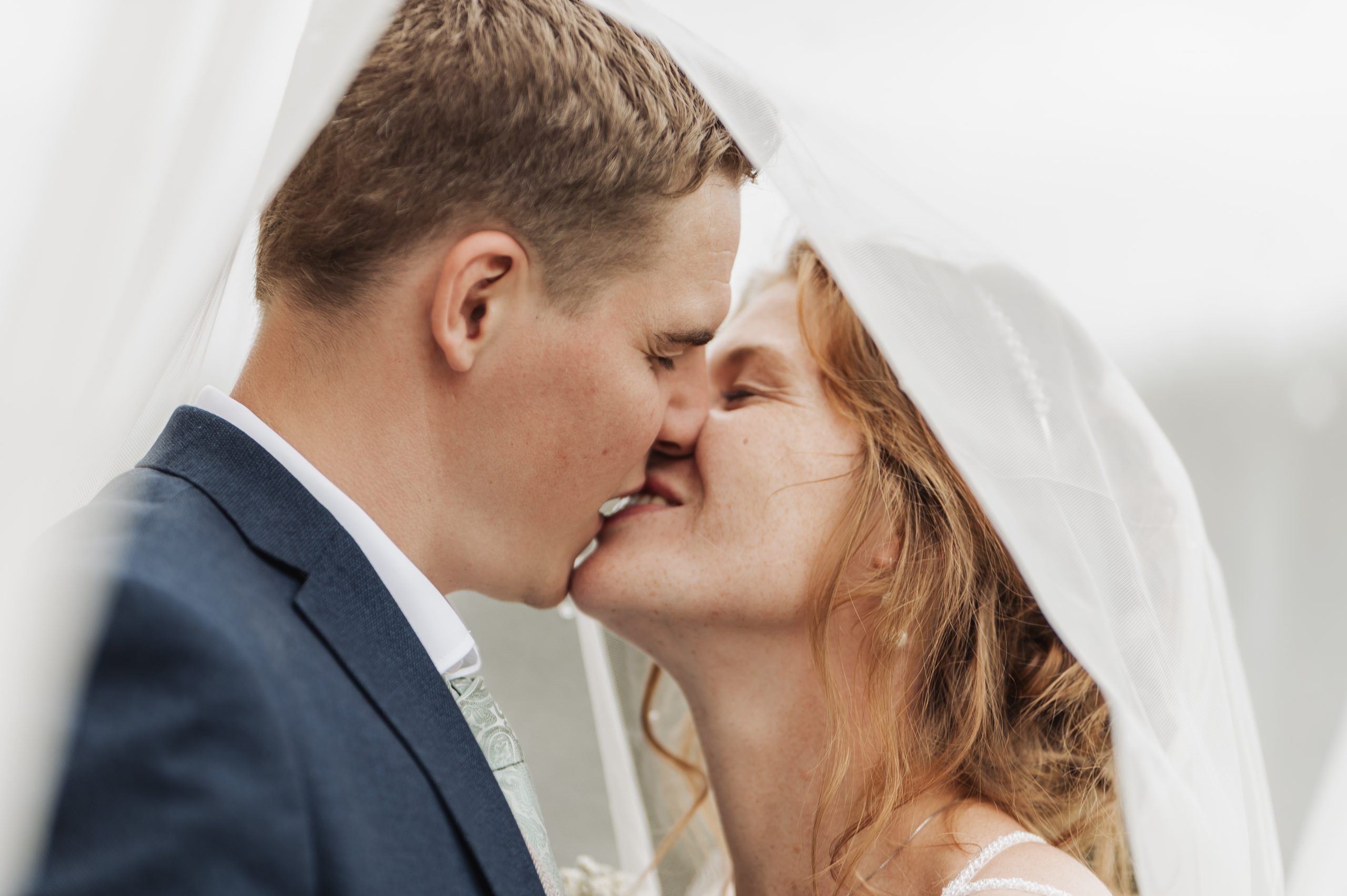 Bride & groom kissing under the veil